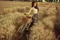 Myloview Fototapeta Kobieta Z Roweru Spoczywa Na Polu Pszenicy O Zachodzi