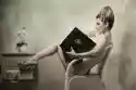 Plakat Naga Kobieta Siedzi W Fotelu Czyta Książkę W Domu