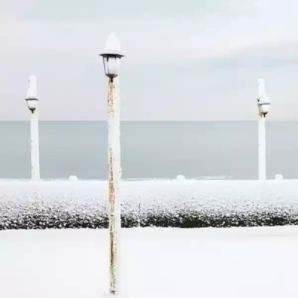 Fototapeta Lampa Pokryta Śniegiem Na Plaży Oceanu W Zimie