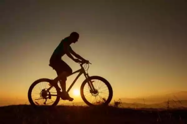 Plakat Biker-Girl Na Zachód Słońca W Górach